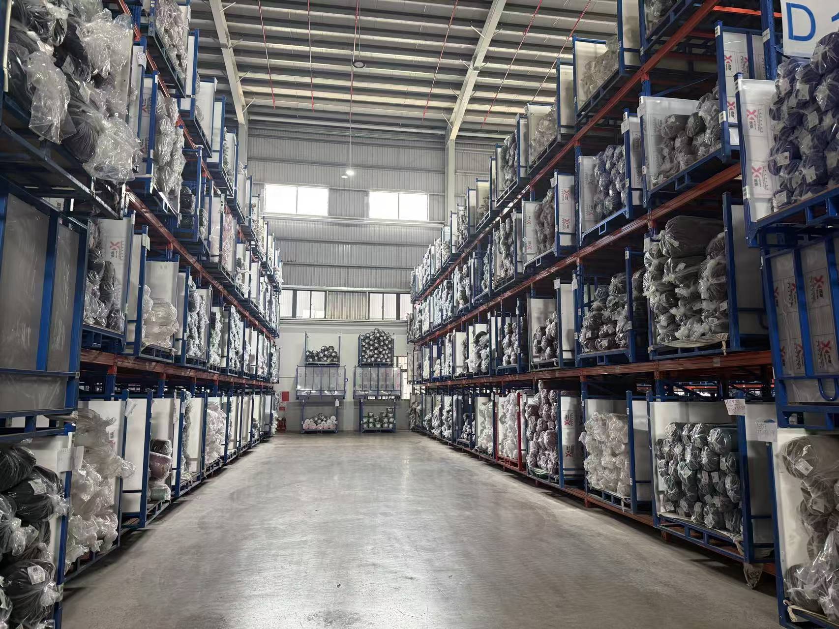 Warehouse racking stacked with bagged finished fabric inventory, ready for export.